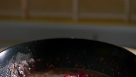 a tilt shot panning down to reveal a low calorie protein pudding topped with a generous helping of tasty red currants served in a black dessert bowl