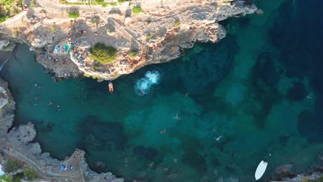 bird's eye view people jumping off the cliff into water, avlemonas greece