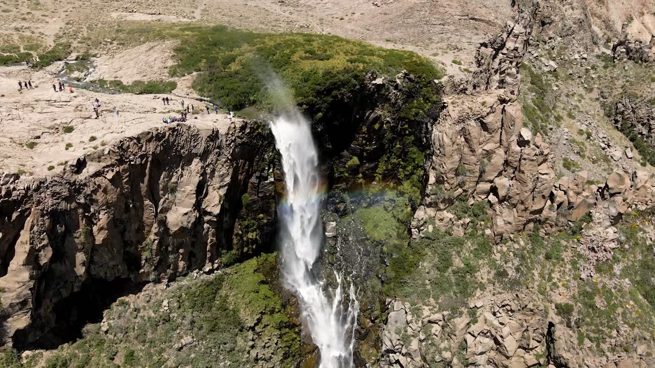 órbita aérea de la cascada invertida con un arco iris constante a su alrededor en maule, chile en un día soleado