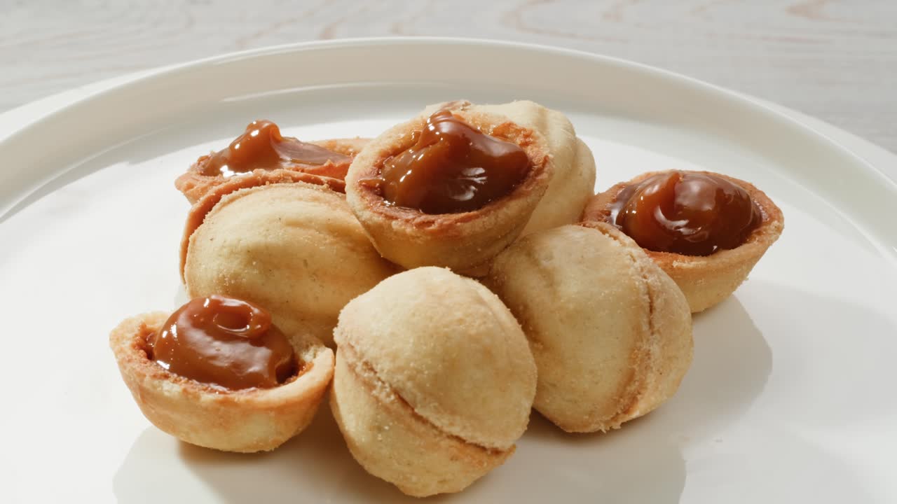 galletas caseras en forma de nuez con leche condensada hervida en una mesa gris, plana. imágenes de alta calidad en 4k