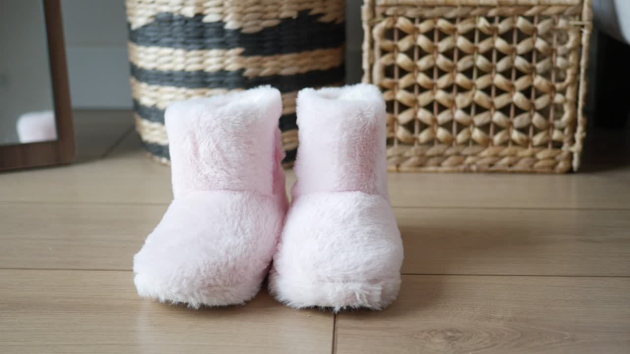 Pair of Pink Fuzzy Slippers on Wooden Floor