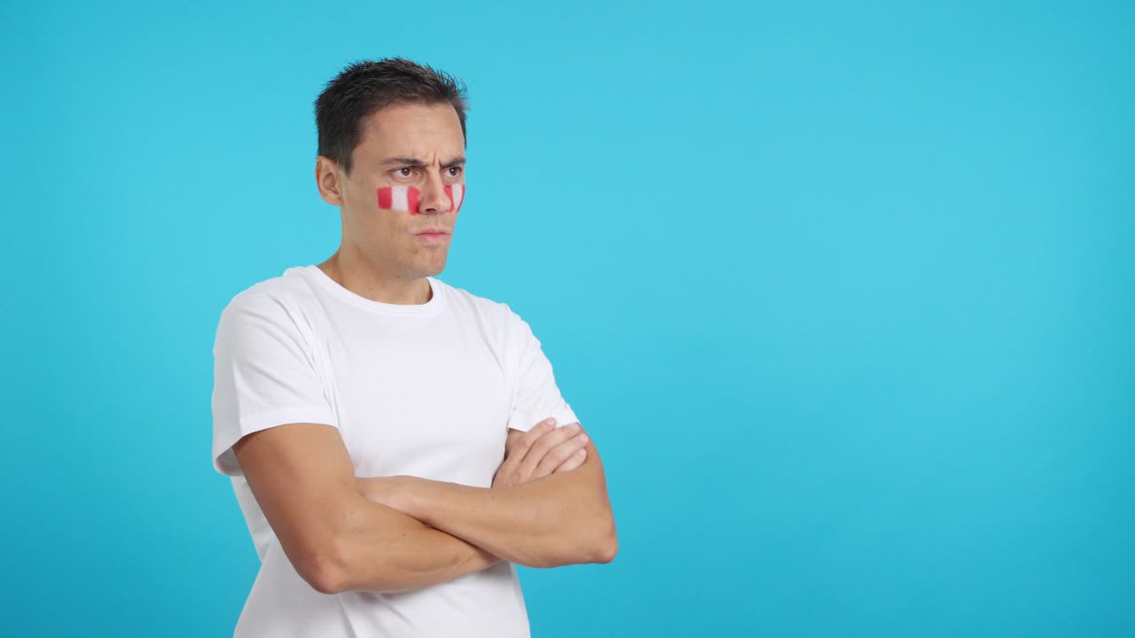 Man with peruvian flag painted looking away with serious expression