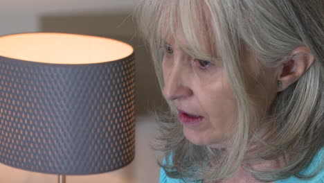 woman looking down at something near a lamp