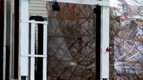 White-door-frame-with-plastic-sheeting-in-a-warehouse,-industrial-setting,-selective-focus