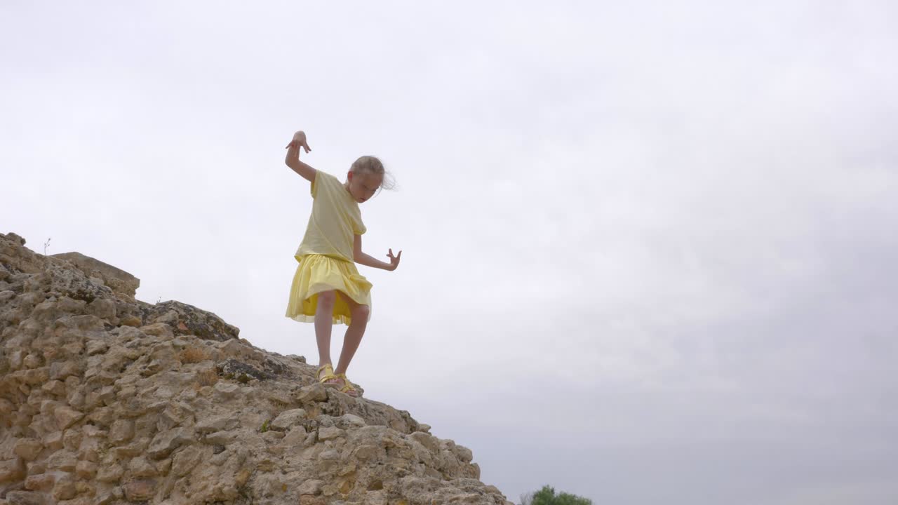 chica adolescente divertida caminando por las antiguas escaleras de roca