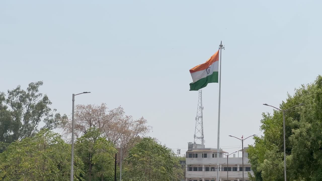Static shot of an Indian tricolor flag flying elegently in the middle ...