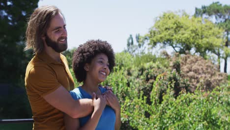 Pareja-De-Raza-Mixta-Abrazándose-Y-Disfrutando-De-La-Vista-Mientras-Están-De-Pie-En-El-Balcón-De-Casa