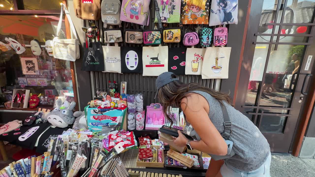 mujer hispana comprando productos japoneses de un vendedor callejero en little tokyo, los ángeles