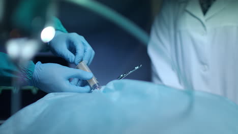 surgeon hands pouring blood in syringe at surgical procedure. medical operation