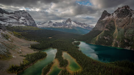 time lapse of pristine nature of canada, clouds moving above picturesque valley and snow capped hills