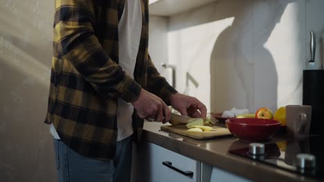 hombre cortando manzanas en una cocina