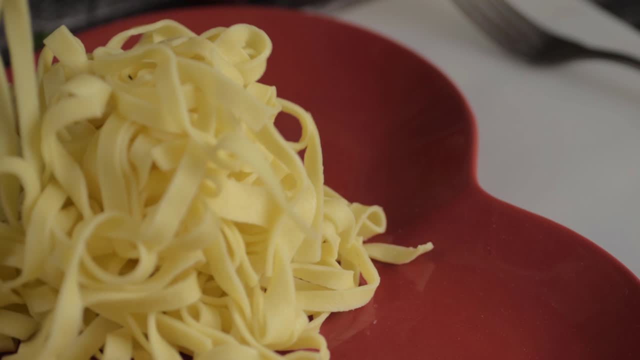 Serving freshly cooked tagliatelle pasta close up shot
