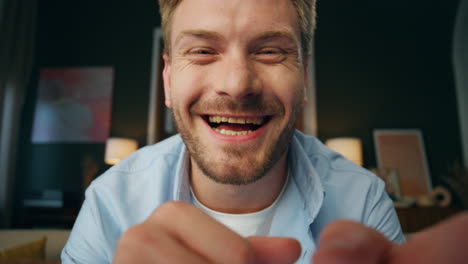 Laughing-businessman-videocalling-at-room-web-camera-view.-Man-nodding-head