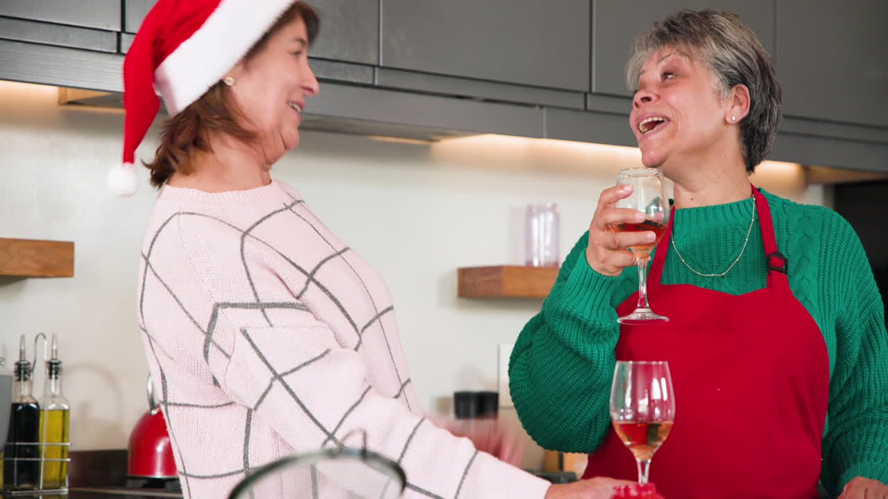 At Christmas, Senior women enjoying festive drinks at home, sharing laughter and holiday cheer