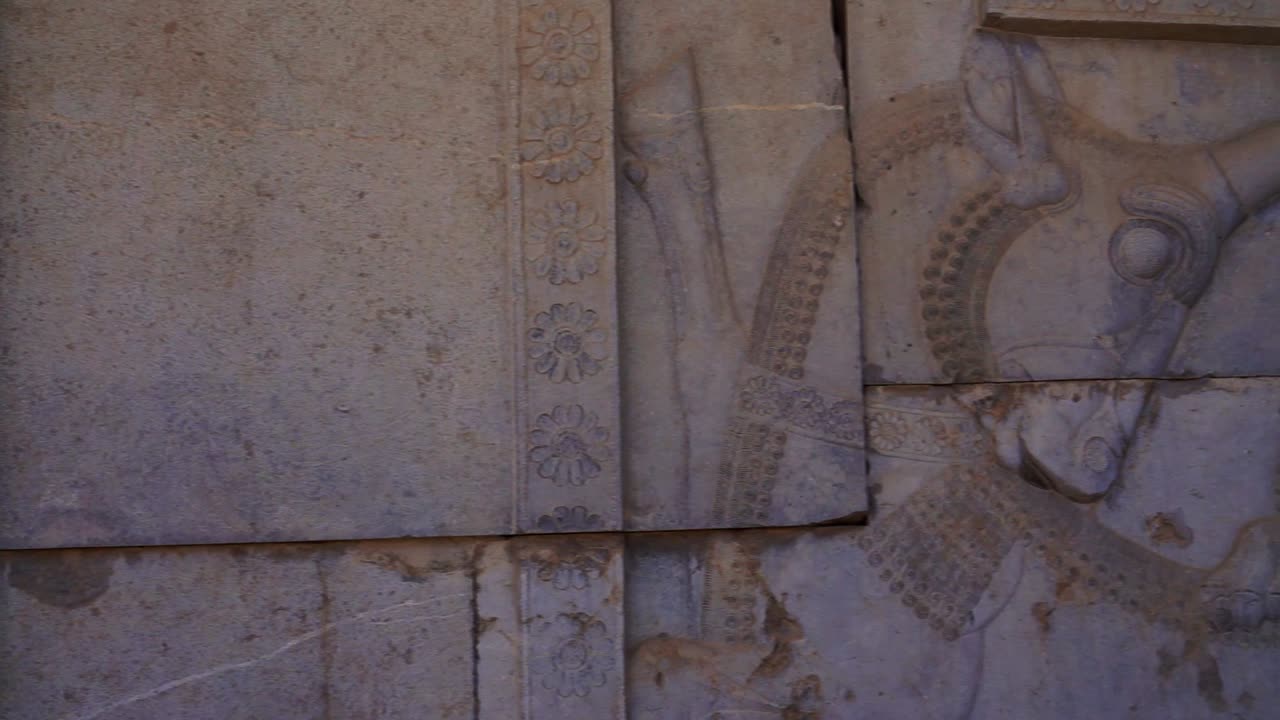 Panning right | Persepolis Lion and Bull Relief | Ancient ruins of Persepolis near Shiraz, Southern Iran. This walls's relief shows many things in the past of Persian empire | Silk Road Iran