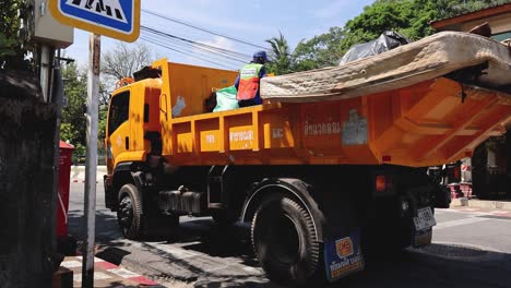 a dump truck tips its bed while driving