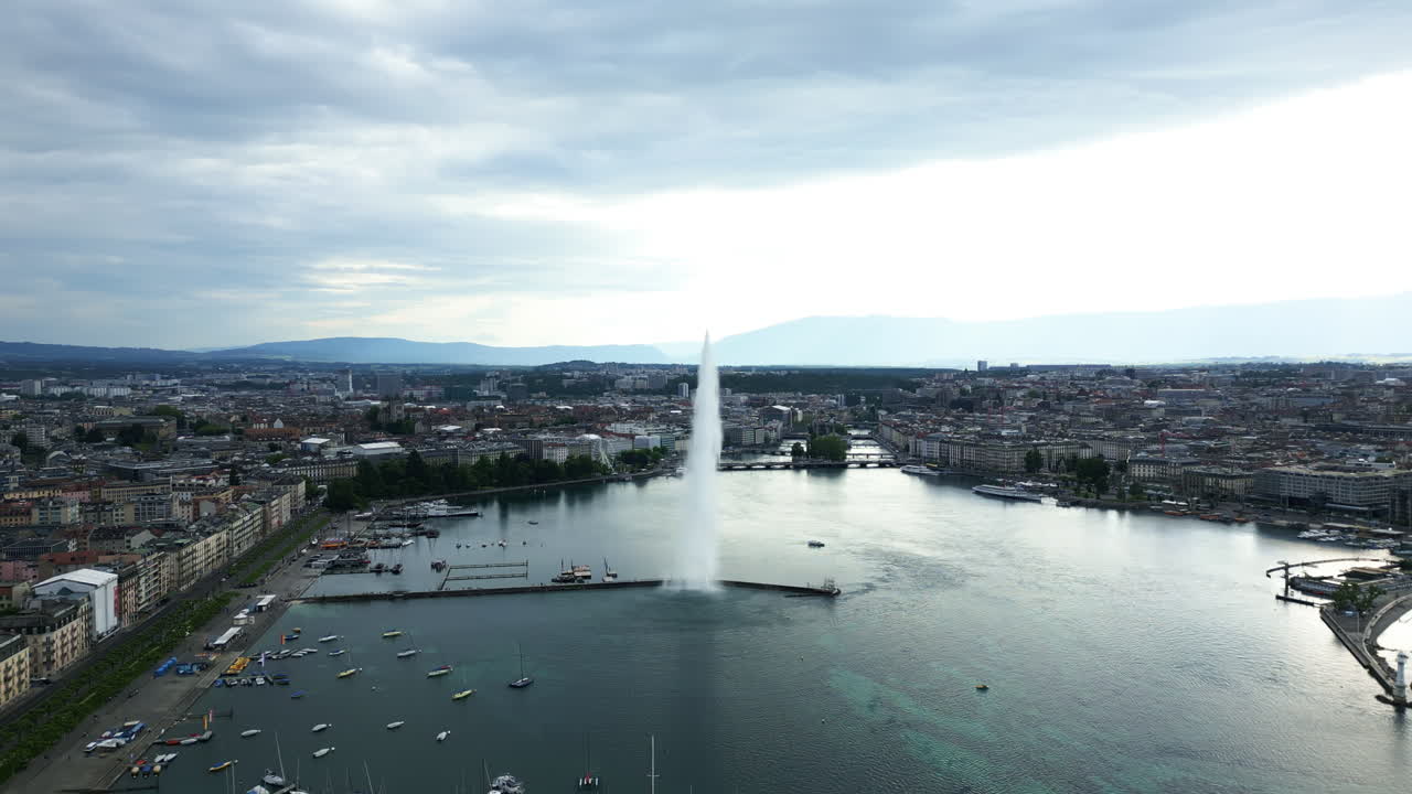 Aerial: water fountain of Geneva during the day (Rade of Geneva) in canton of Geneva, Switzerland, pull out drone shot