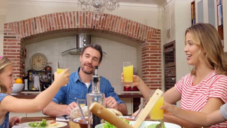 familia feliz brindando con jugo de naranja