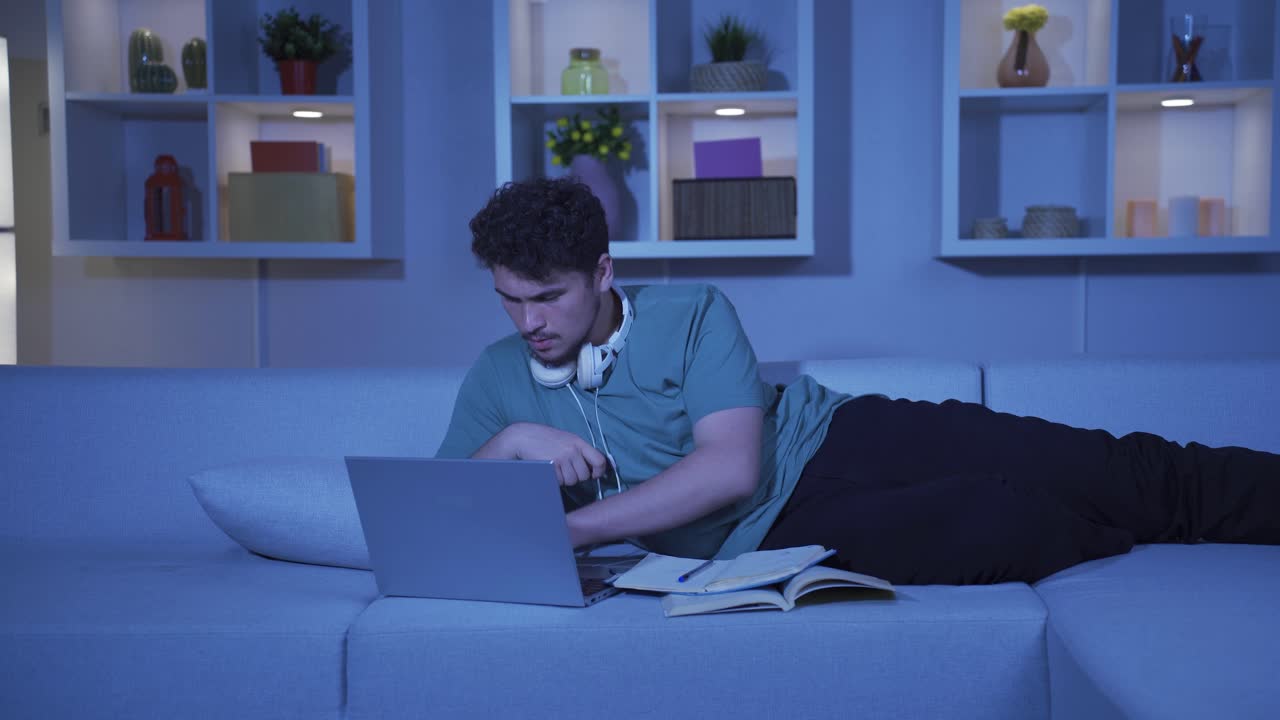 A male student who is happy that his exam results are good. At home at night.