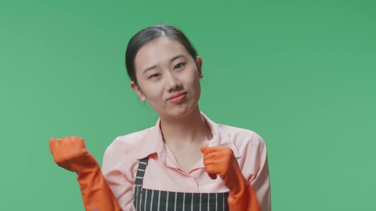녹색 스크린 스튜디오에 서서 춤을 추는 즐거운 아시아 여성 집주인의 클로즈업