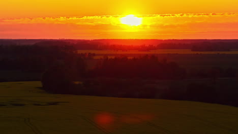 golden sunset casting glow over fields and distant trees on rural farmland