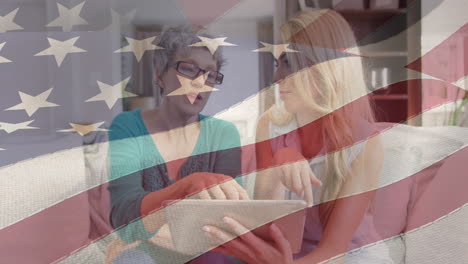 animación de la bandera estadounidense sobre madre e hija usando tableta en casa