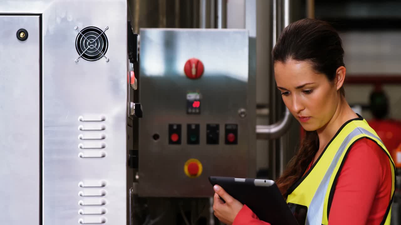 mujer que utiliza maquinaria en la planta de botellas