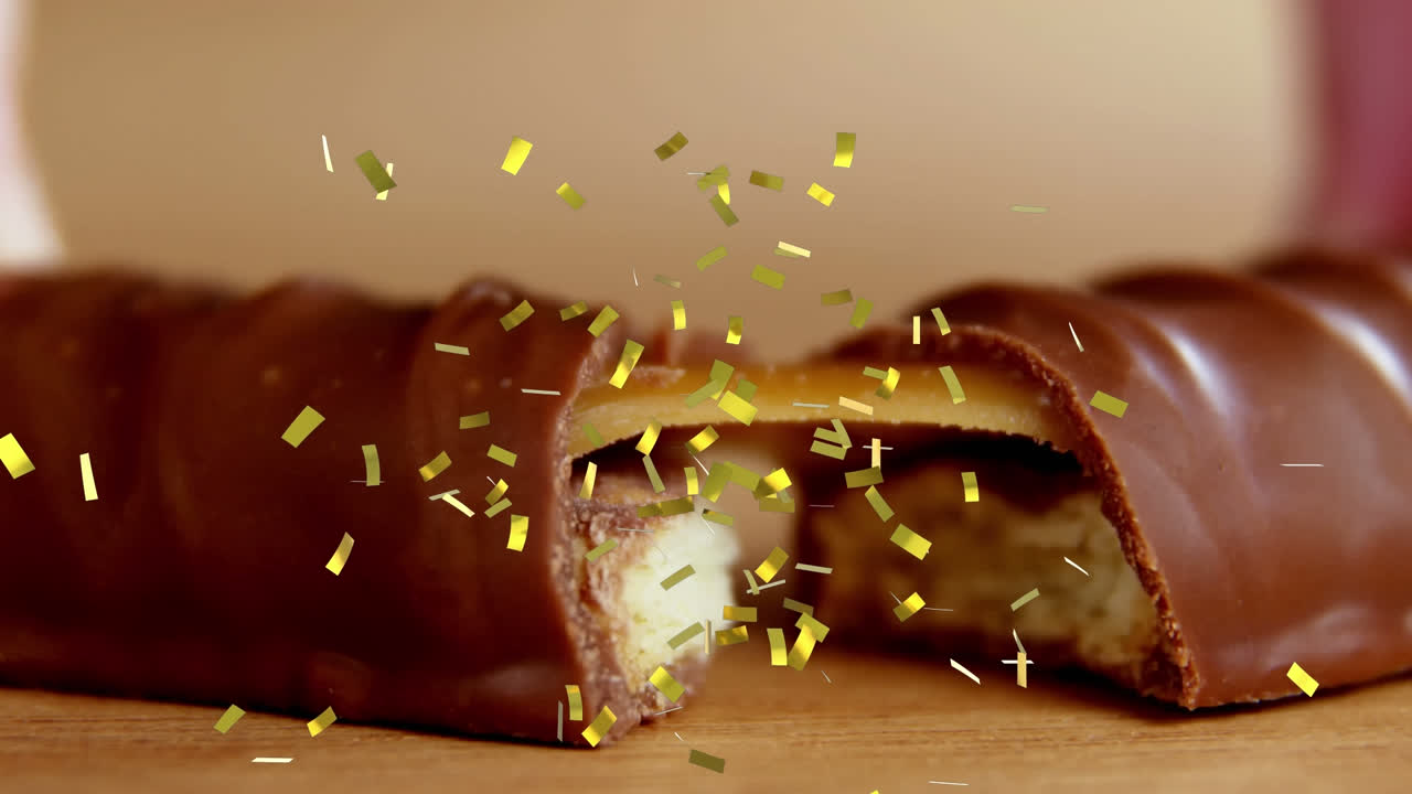 animación de confeti dorado cayendo sobre galletas rotas y barra de chocolate de caramelo