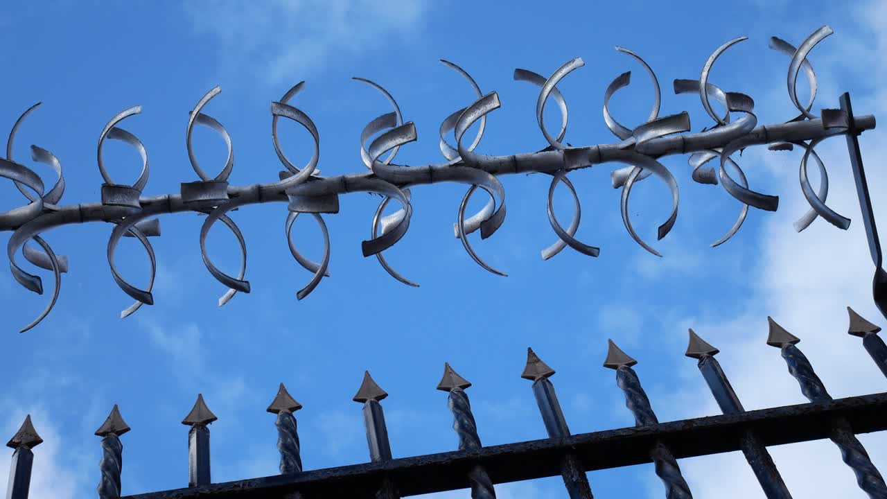 푸른 흐린 하늘을 바라 보는 감옥 철조망 강철 문 느린 돌리 왼쪽