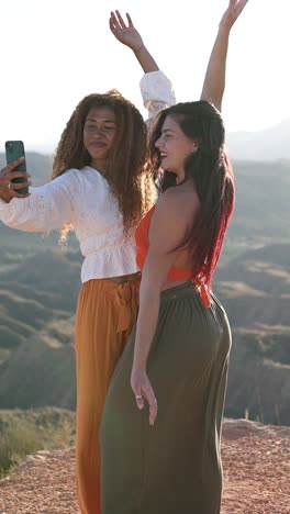 friends taking a selfie outdoors in a sunny mountain landscape
