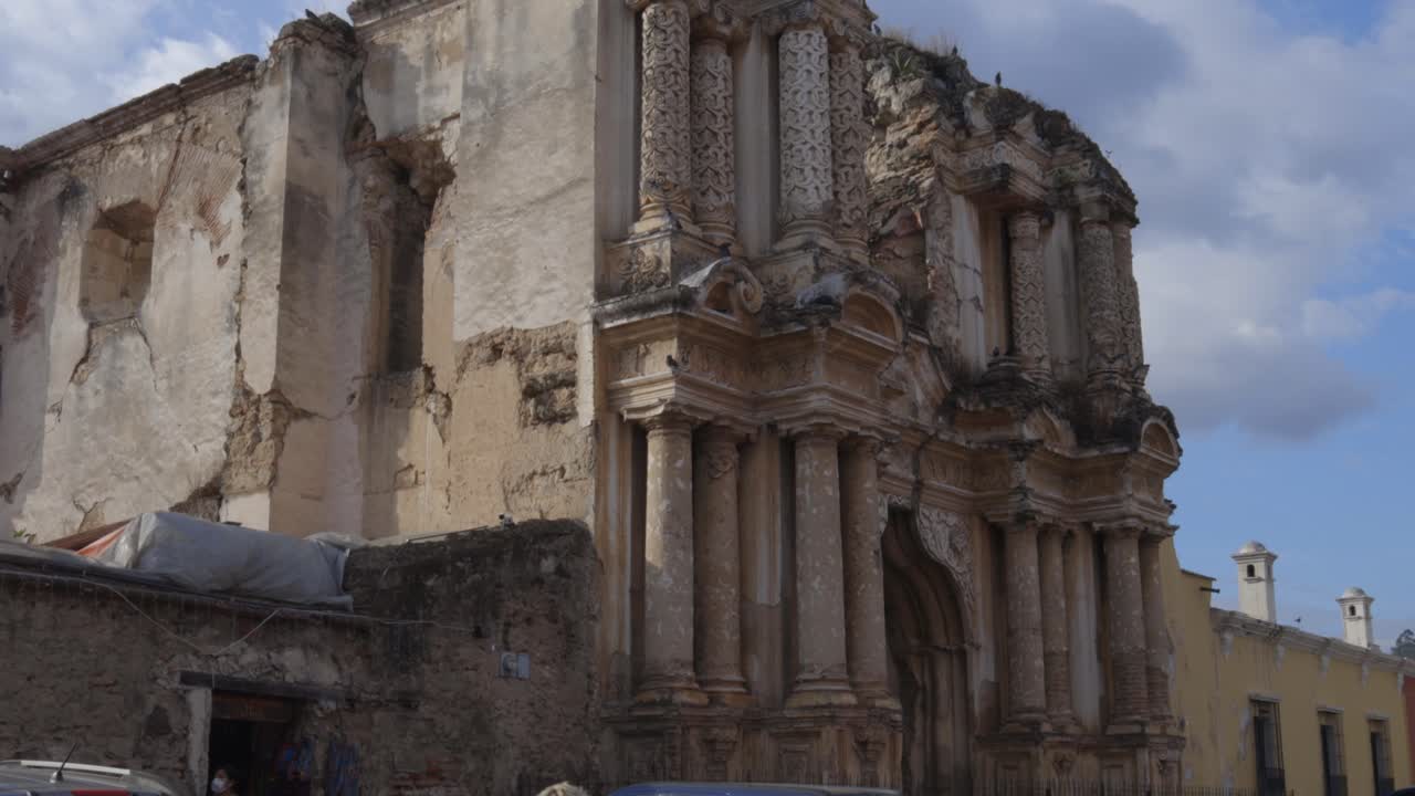 Street scene in Antigua City, Guatemala with cobblestone road and colonial architectural ruins, daytime establishing