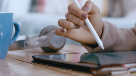 close up woman hands using tablet computer with stylus pen browsing data checking emails on mobile touchscreen device relaxing at home