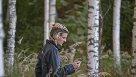 woman using phone in a forest