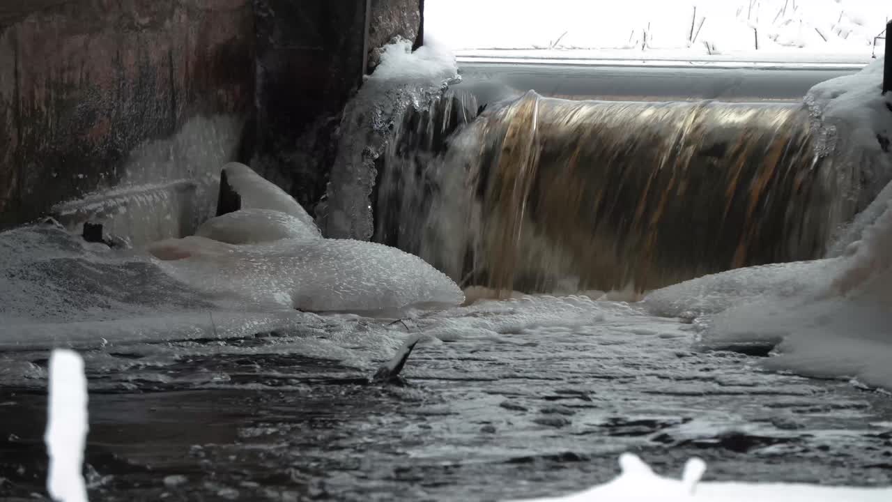 pure water stream by winter and snow heap in middle