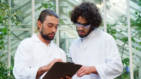 men shaking hands and interacting while taking notes
