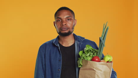 Vegan-person-showing-a-stop-sign-with-his-palm-while-he-carries-a-bag