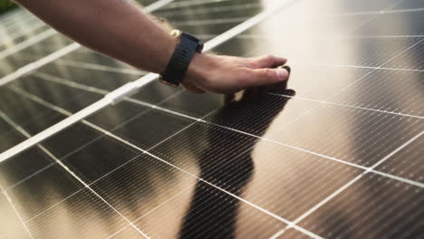 man's hand touching a solar panel. - closeup shot