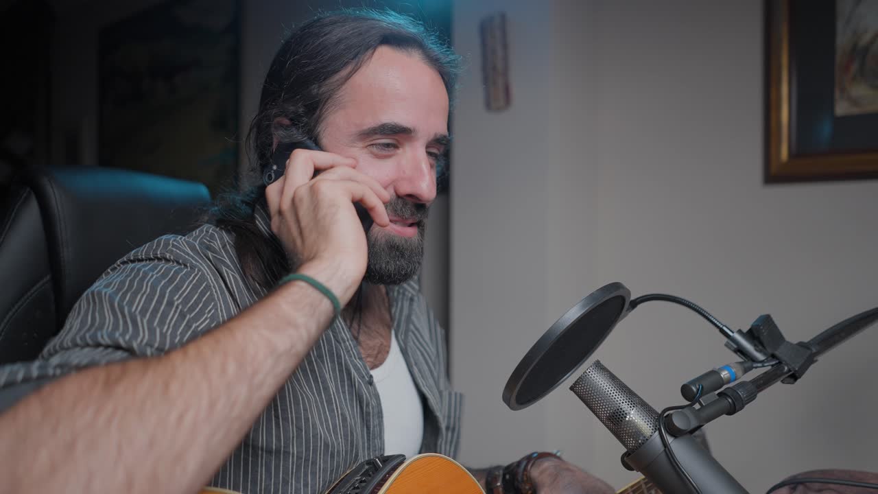 Musician on a phone call in a home recording studio