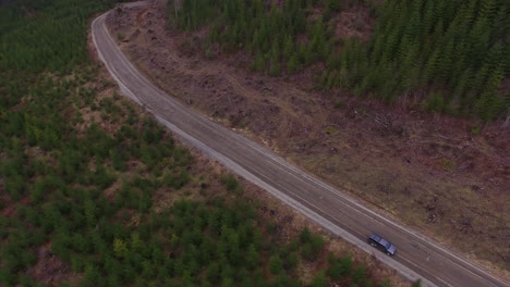 Beautiful-aerial-of-a-4WD-truck-driving-through-the-Cascades-Wilderness-in-Washington-USA-1