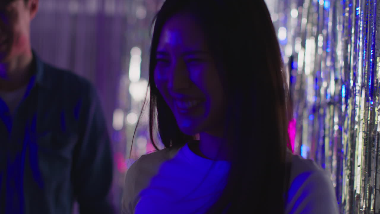 나이트클럽 이나 페어 1 에 있는 틴셀 커튼 을 지나가는 젊은 친구 들 의 그룹