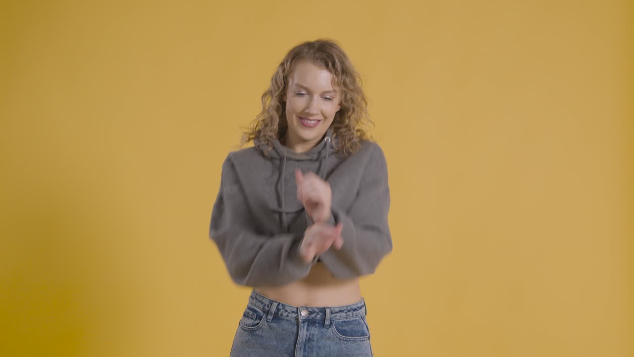 foto de estudio de una joven que se divierte bailando contra un fondo amarillo