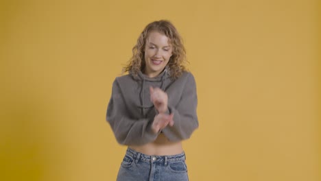 foto de estudio de una joven que se divierte bailando contra un fondo amarillo