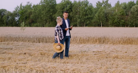 jóvenes agricultores discutiendo en el campo de trigo 9