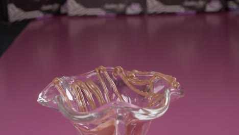 pouring caramel syrup over a glass dessert