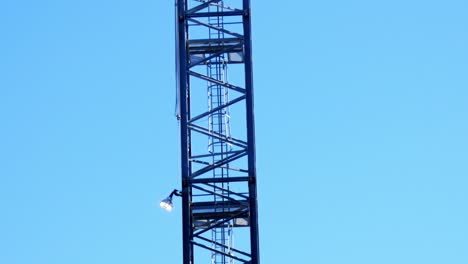 camera panning down a cranes structure with blue sky in background