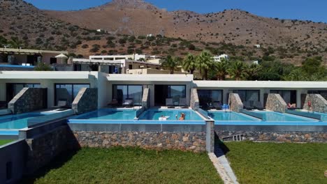 una mujer disfruta de una bebida exótica en la piscina del elounda palm hotel and suites