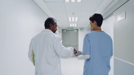 Two-doctors-walking-in-hospital-corridor-talking-4k