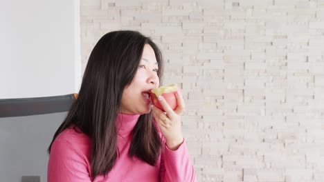 close up of young asian woman eating a fresh apple