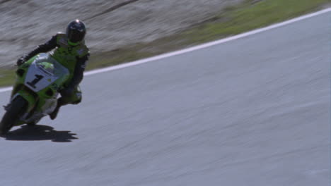 motorcyclists race around a track spectators watch