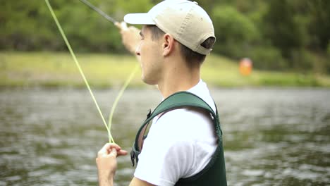 toma en cámara lenta de un pescador caucásico lanzando su anzuelo mientras pesca con mosca-10